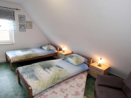 Zimmer im Dachgeschoss mit 2 Betten und 2 Lampen in der Unterkunft Doppelhaushälfte Friesenglück mit Sauna in Dornumersiel