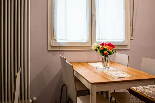 une table de salle à manger avec un vase de fleurs dessus dans l'établissement Sweet Harbour PORTO - Affittacamere, à Pesaro