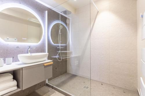 uma casa de banho com um lavatório e uma cabina de duche em vidro. em Les Tours Carrées em La Motte-Servolex