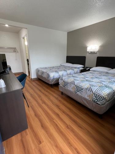 two beds in a hotel room with wooden floors at Motel 6-Longview, TX in Longview