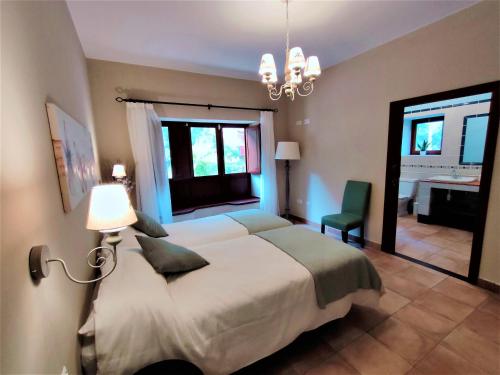 a bedroom with a large white bed and a desk at Haciendita Gomera in San Sebastián de la Gomera