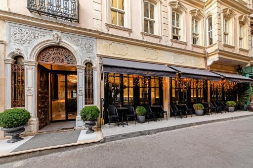 uma loja em frente a um edifício com mesas e cadeiras em Meroddi Barnathan Hotel em Istambul