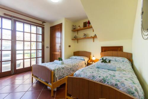 a bedroom with two beds and a window at Il tramonto visto da casa in Calasetta