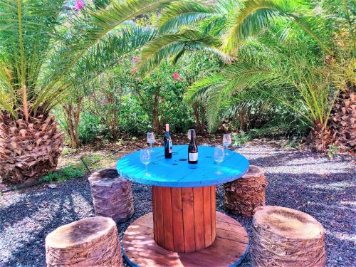 a table with wine bottles and wine glasses on it at Haciendita Gomera in San Sebastián de la Gomera