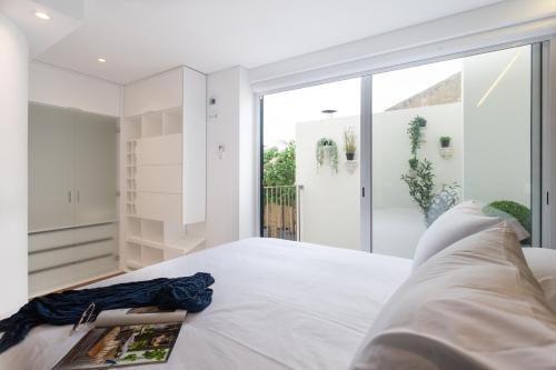 - une chambre avec un lit blanc et une grande fenêtre dans l'établissement Embaixador Apartments&Suites, à Lisbonne