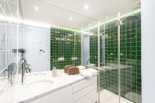 リスボンにあるEmbaixador Apartments&Suitesの緑のタイル張りのバスルーム(シンク、シャワー付)