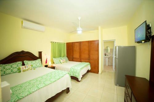 1 dormitorio con 2 camas y nevera en Hotel Enrique I Gazcue, Bed and Breakfast en Santo Domingo