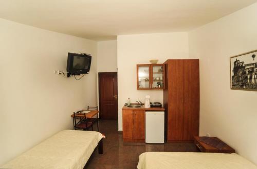 a small room with two beds and a television at Mijovic Apartments in Budva