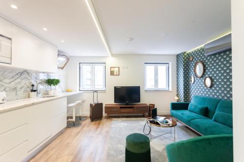 a living room with a blue couch and a tv at Embaixador Apartments&Suites in Lisbon
