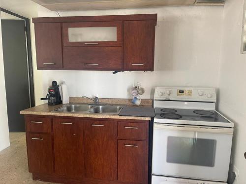 eine Küche mit einem weißen Herd und einer Spüle in der Unterkunft Bayamon Puerto Rico 3 Bedroom Home in Bayamon