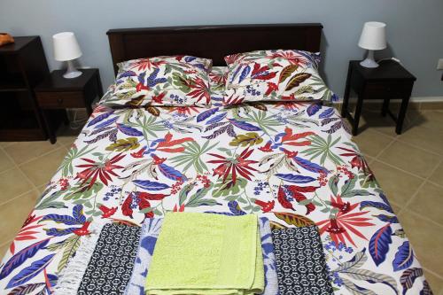 a bed with a blanket and two ties on it at African Sunset in Sal Rei