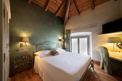 sypialnia z dużym białym łóżkiem i biurkiem w obiekcie Hotel Parco Borromeo - Monza Brianza w mieście Cesano Maderno