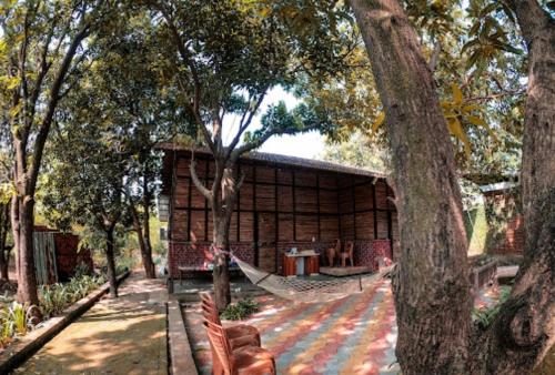 a hammock in front of a log cabin with trees at GREEN VISION RESORT in Murbād