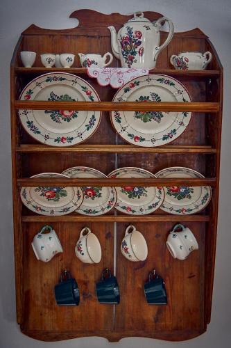a wooden shelf with plates and tea sets on it at Ferienhaus Pucher in Grundlsee