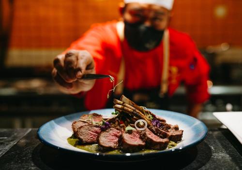 a person wearing a gas mask eating a plate of meat at Villa del Palmar at the Islands of Loreto in Loreto
