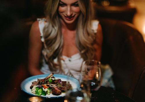 a woman sitting at a table with a plate of food at Villa del Palmar at the Islands of Loreto in Loreto
