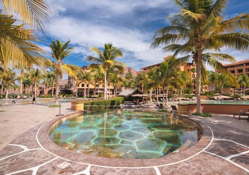 a pool at a resort with palm trees at Villa del Palmar at the Islands of Loreto in Loreto