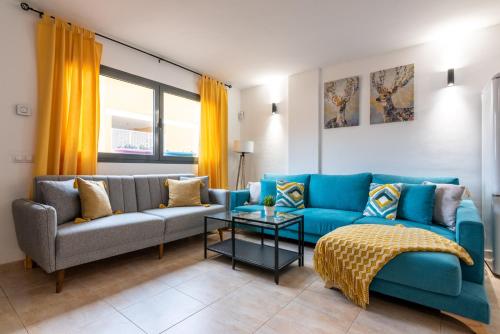 uma sala de estar com um sofá azul e uma mesa em Casa Cotillo 13 next to Los Lagos Beach Highspeed Wifi em Cotillo