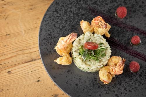 a plate of food with shrimp and vegetables on it at Hotel Bella Vista in Trafoi