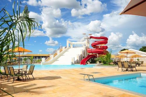 een resortzwembad met een rode waterglijbaan bij Lacqua diroma - Descanso Merecido, Park aquático 24h, Piscina de Ondas Exclusiva in Caldas Novas