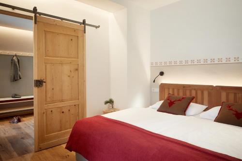 a bedroom with a large bed and a wooden door at Hotel Bella Vista in Trafoi