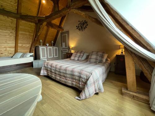 a bedroom with two beds in a room with wooden ceilings at Chambre d'hôtes La Ferme de la Croix. in Saint-Avit-Sénieur