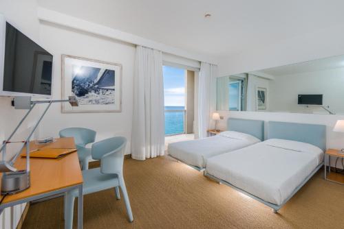 ein Hotelzimmer mit einem Bett, einem Schreibtisch und einem Schlafzimmer in der Unterkunft Hotel Miramare - Adults Only in Triest