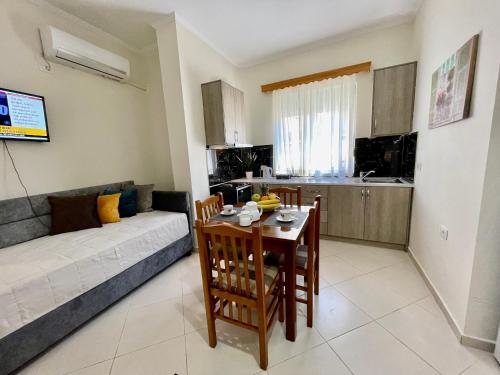 a living room with a table and a couch at Relax Apts Saranda in Sarandë