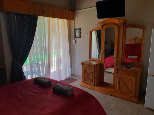 a bedroom with a mirror and a dresser and a bed at Chariots Guest House in Polokwane