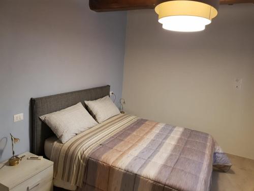 um quarto com uma cama com um cobertor listrado em Agriturismo Villa al piano em Todi