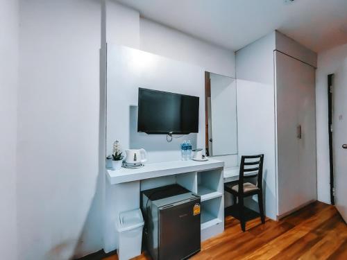 a room with a desk with a television and a chair at The Harbour Front Hotel in Suratthani