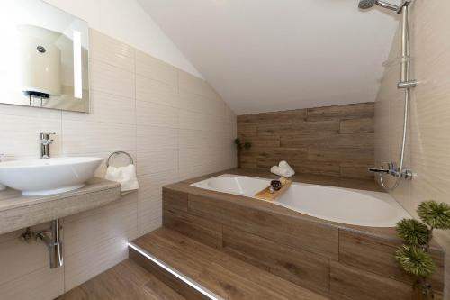 a bathroom with a bath tub and a sink at Deluxe Apartment Stunning view in Jadranovo