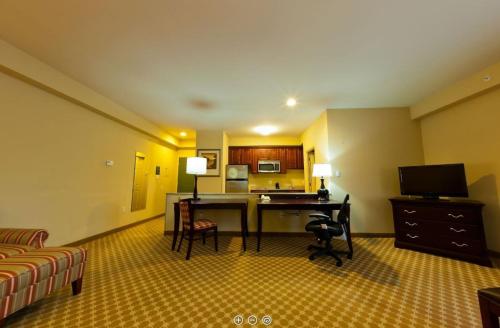 a hotel room with a desk and a couch at Country Suites Absecon-Atlantic City, NJ in Galloway