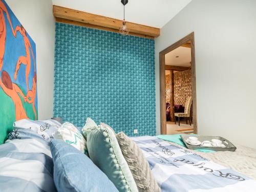 ein Schlafzimmer mit einem Bett mit einer blauen Wand in der Unterkunft Słoneczne Studio z widokiem na morze in Sopot