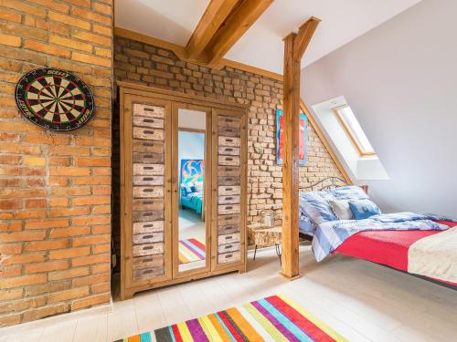 ein Schlafzimmer mit einer Ziegelwand, einem Bett und einem Spiegel in der Unterkunft Słoneczne Studio z widokiem na morze in Sopot