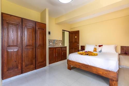 a bedroom with a bed and wooden cabinets at Hotel Turístico Marian in Las Terrenas