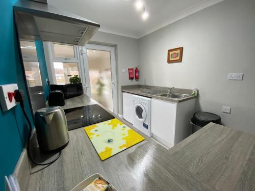 een keuken met een wastafel en een wasmachine bij Bijou Abode- Driffield - free private parking and secure cabin in Great Driffield