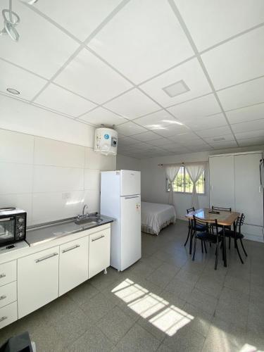 eine Küche und ein Esszimmer mit einem Tisch und einem Kühlschrank in der Unterkunft Departamento en La Punta in La Punta