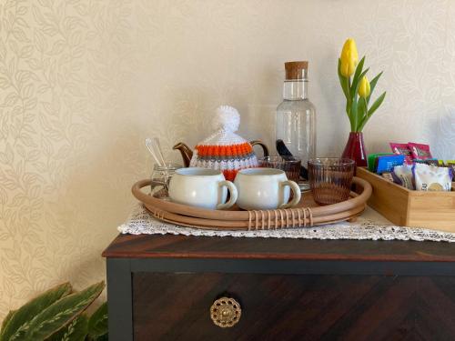 a tray with two cups and a bottle on a table at Heathpark House in Blairgowrie