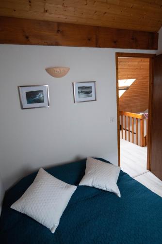 - une chambre avec un lit bleu et 2 oreillers dans l'établissement Chalet mitoyen tout confort, à Cauterets