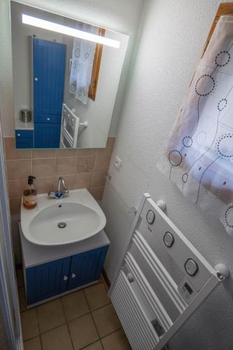 une salle de bain avec un lavabo, un miroir et une douche dans l'établissement Chalet mitoyen tout confort, à Cauterets