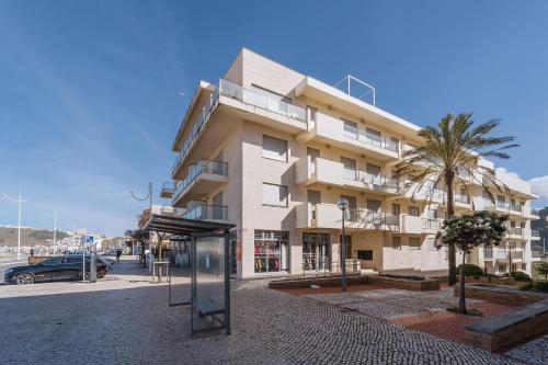een gebouw met een bushalte voor de deur bij Refúgio Villa Mar in Nazaré