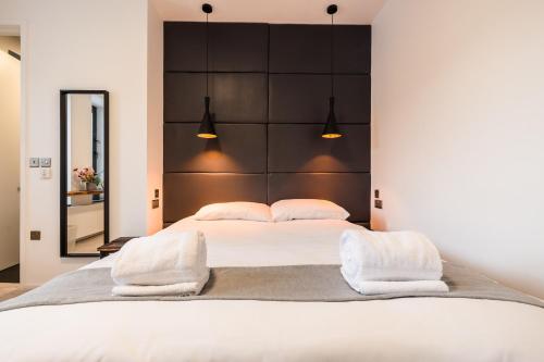a bedroom with a large white bed with two pillows at Cardiff Arms Bistro & Hotel in Treorky