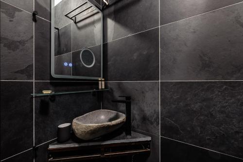 a bathroom with a stone sink and a mirror at Cardiff Arms Bistro & Hotel in Treorky