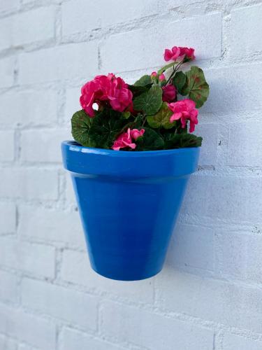 a blue pot of flowers hanging on a wall at Casa Abuela Nila in Cogeces de Iscar