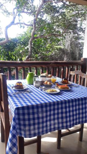 un tavolo a scacchi blu e bianco con sopra del cibo di Pousada Turquesa mirante com vista para as montanhas e por do sol a Serra do Cipo