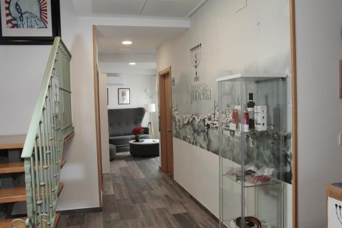 a hallway with a staircase and a display case at Hospedium Hostal Temático Desde La Judería in Arjona