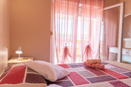 une chambre avec un lit avec une grande fenêtre dans l'établissement MERI, à Rab