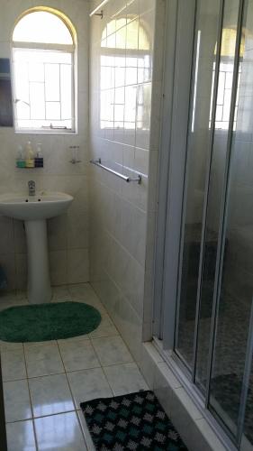 a bathroom with a sink and a shower at Chariots Guest House in Polokwane