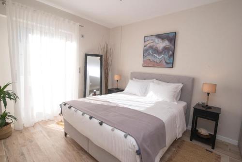 a bedroom with a white bed and a window at Chrysalis 1 in Kos
